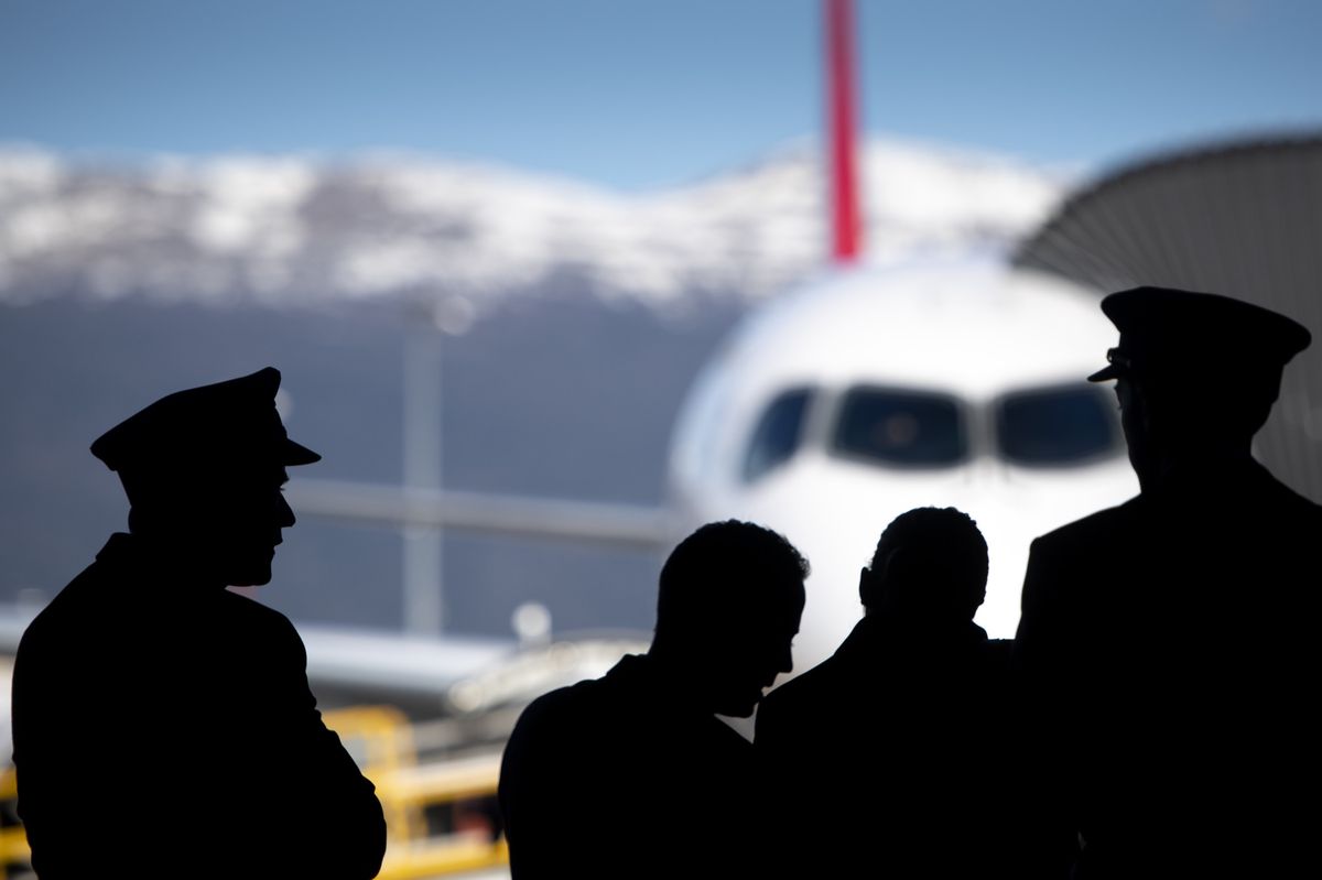 L’équipage attend devant un avion de la compagnie Swiss sur le tarmac à l’aéroport de Genève.