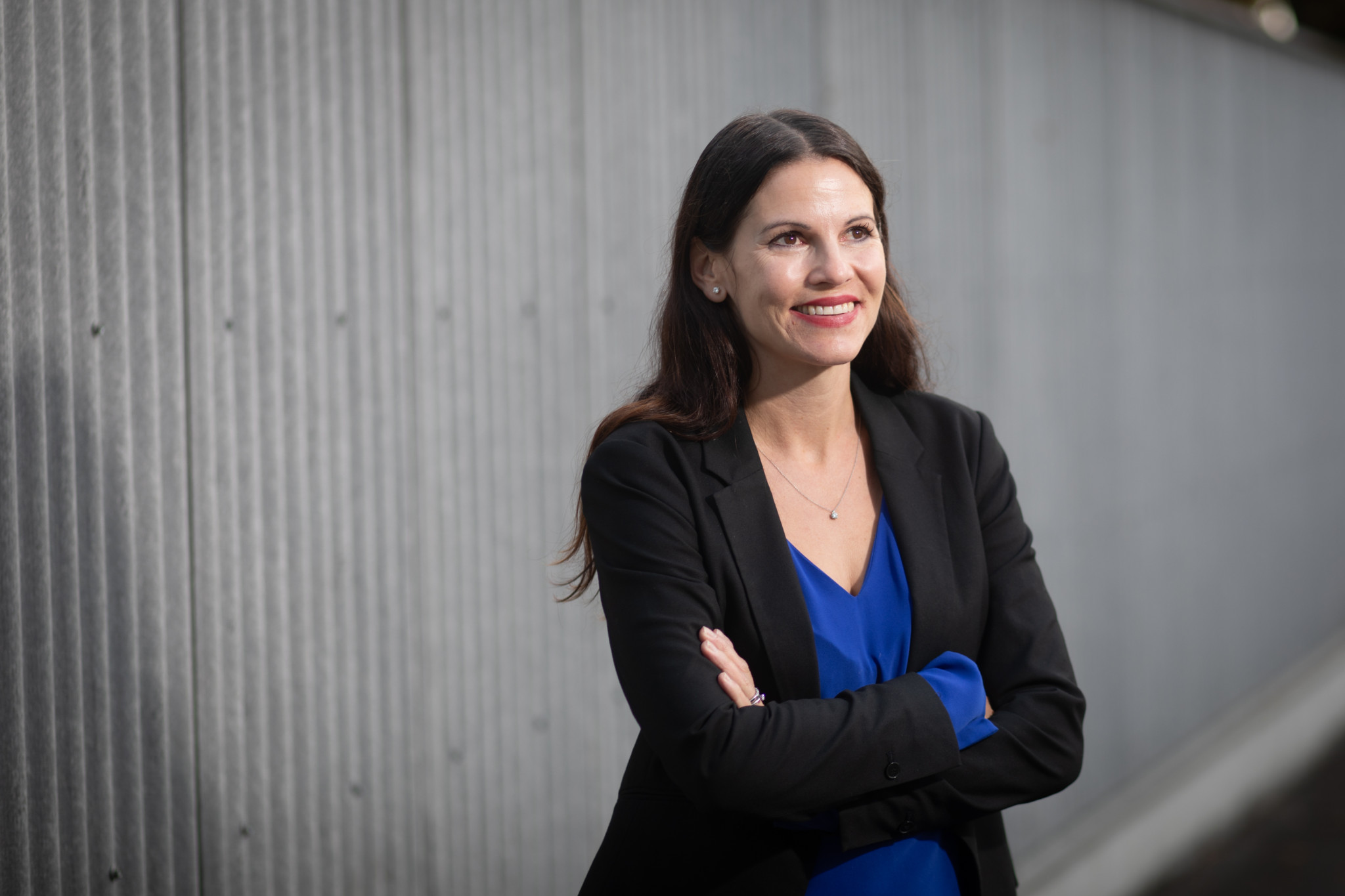 Nina Fehr Düsel, Nationalrätin der SVP, lächelnd mit verschränkten Armen vor einer grauen Wand in Zürich, 25.10.2023.