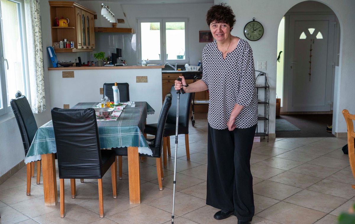 Sonia Freda Tschumy, 38 ans, se tenant debout avec une canne dans sa cuisine après avoir subi un AVC, Yens, 18 octobre 2024.