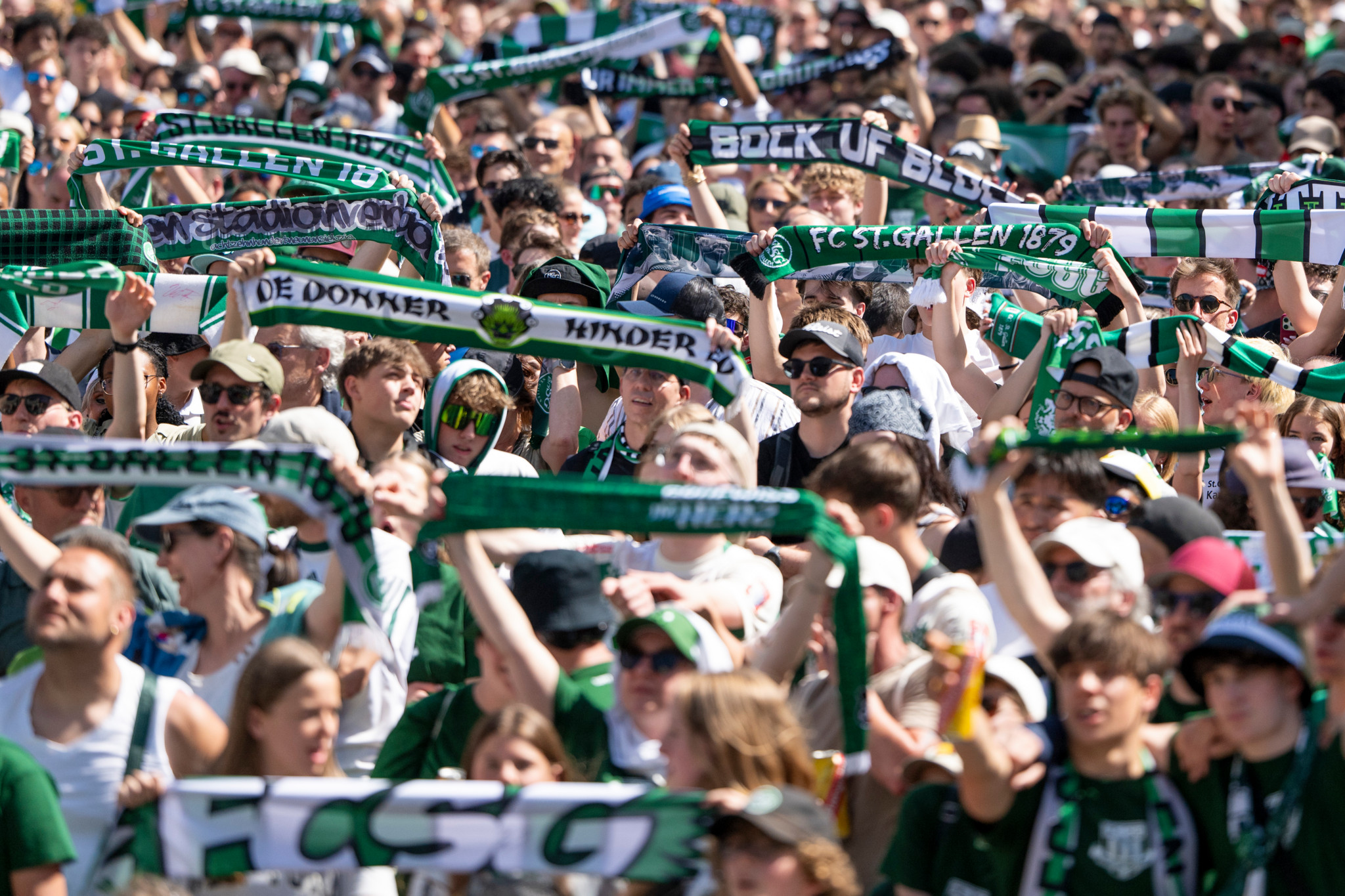FC St. Gallen Fans jubeln beim Public Viewing zum Schweizer Cup Finale 2026 und halten Schals mit Aufschriften wie «FCSG» und «Bock uf Blau» hoch.