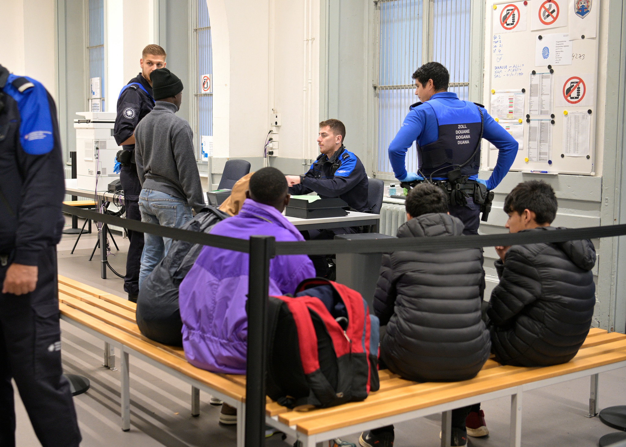Chiasso,  le 24 octobre 2023. Dans un bureau à la gare de Chiasso des gardes-frontière contrôlent des migrants en provenance d'Afrique, arrêtés lors d'un contrôle dans le train circulant entre l'Italie et la Suisse.  24HEURES/Chantal Dervey