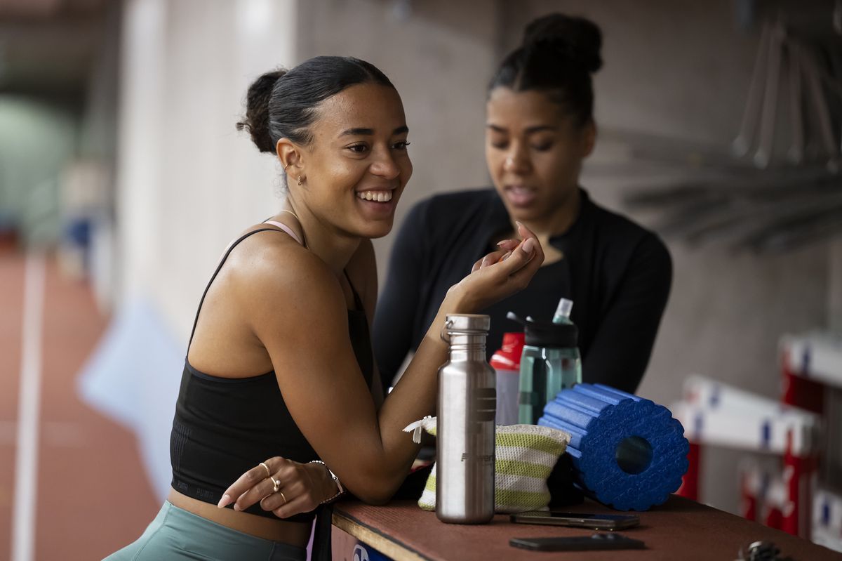 ARCHIV - ZUM MULTIMEDIA-PAKET ZU OLYMPIA PARIS 2024 UEBER DITAJI UND MUJINGA KAMBUNDJI STELLEN WIR IHNEN FOLGENDES BILDMATERIAL ZUR VERFUEGUNG - Die Leichtathletin Ditaji Kambundji, links, lacht neben die Leichtathletin Mujinga Kambundji, rechts, beim Training, am Freitag, 12. April 2024 im Leichtathletikstadion Wankdorf in Bern. (KEYSTONE/Anthony Anex)