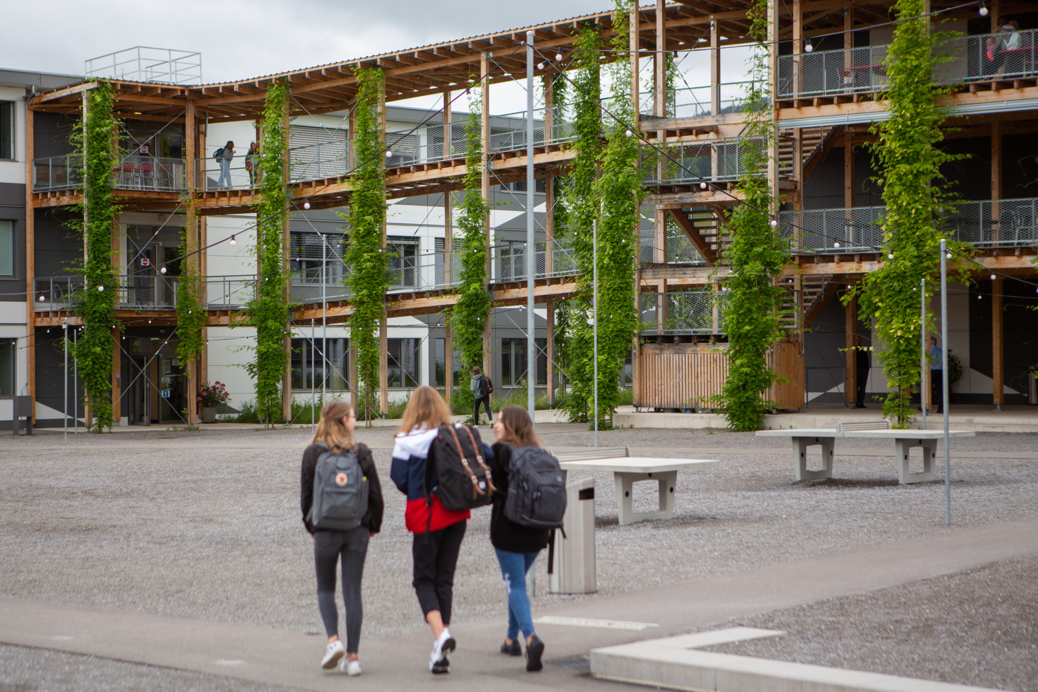 Drei Schülerinnen mit Rucksäcken gehen auf das Gymnasium Uetikon zu, das nach Corona-Pause wieder öffnet, Juni 2020.