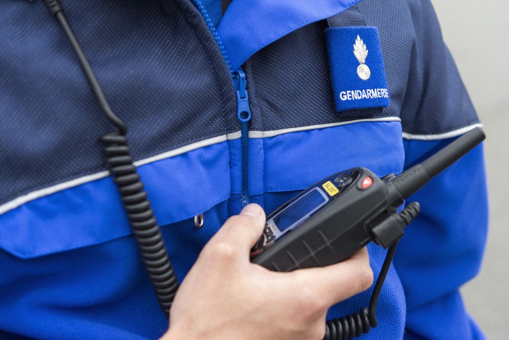 Un policier de la police cantonale de Fribourg avec un appareil radio.