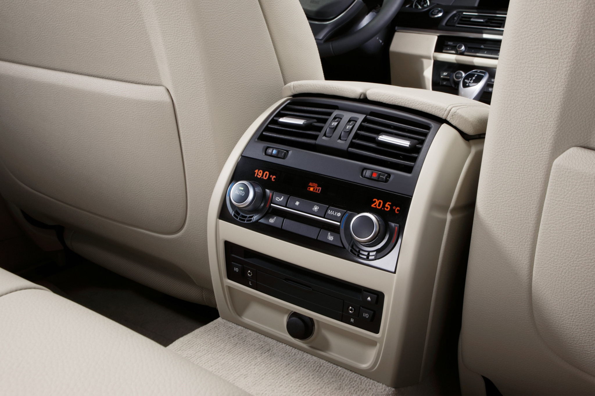 Klimabedieneinheit im Fond eines BMW 5er mit Temperaturanzeigen 19,0°C und 20,5°C, eingebettet in beigem Lederinterieur.