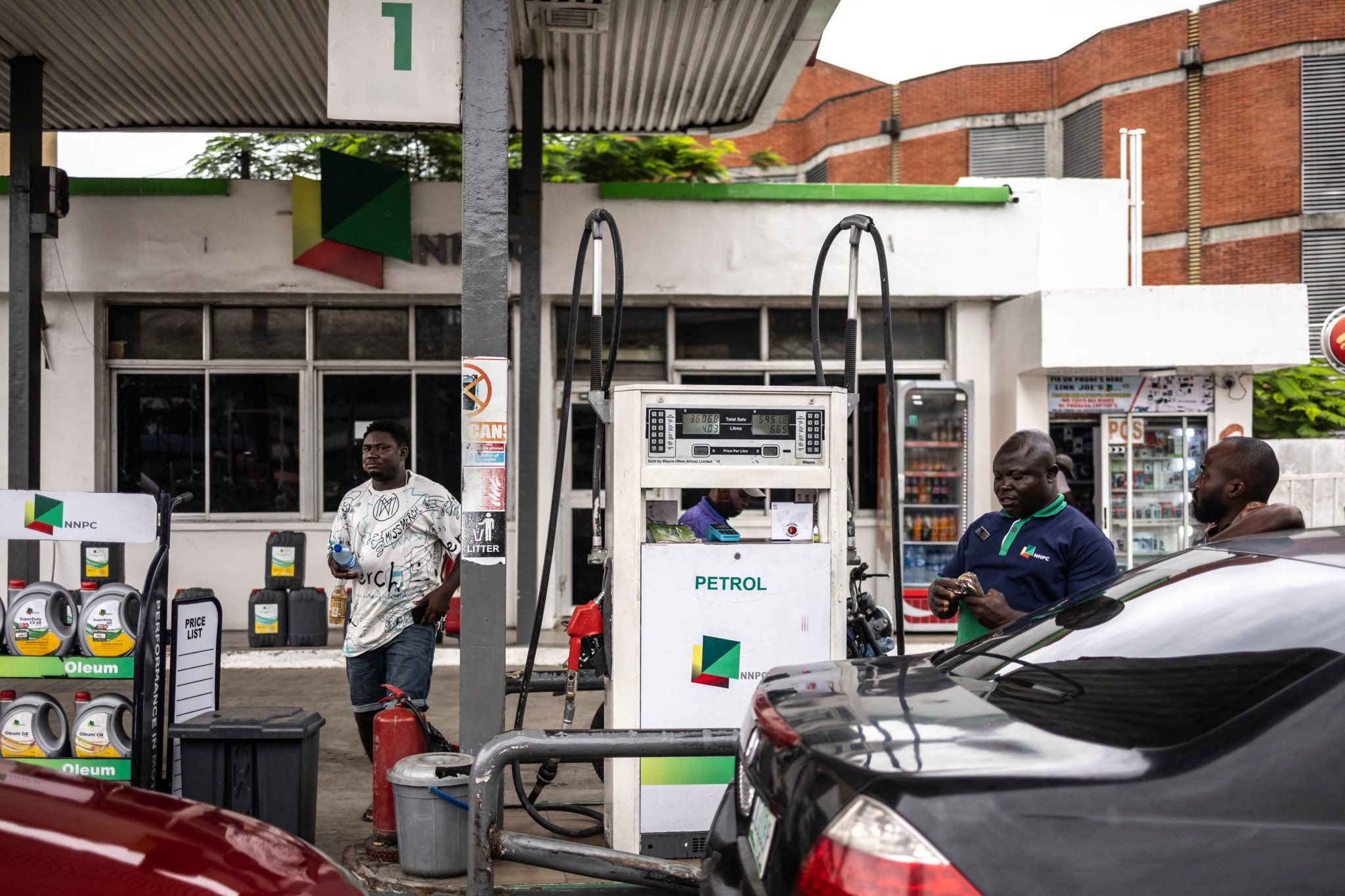 Un pompiste compte de lâargent dans une station-service près de la route Awolowo à Lagos, le 13 août 2025.
