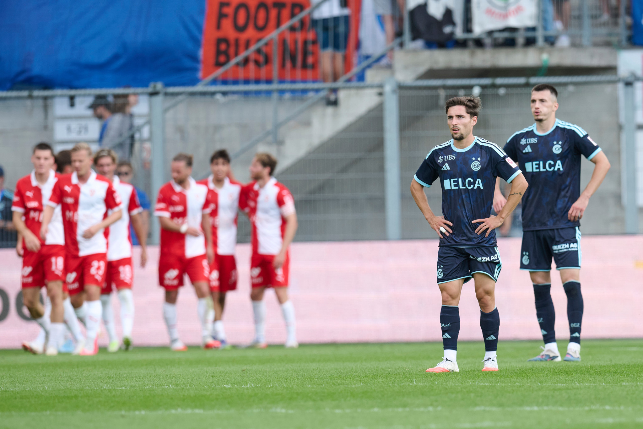 Samuel Marques von GC steht enttäuscht auf dem Platz, während Vaduz-Spieler im Hintergrund jubeln – Super League in Vaduz.