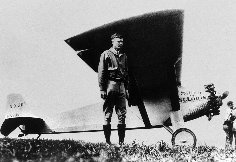 En 33 heures et 30 minutes, du 20 au 21 mai 1927, l'aviateur américain a réalisé l'exploit de relier New-York à Paris sans escale et en solitaire. On le voit ici poser devant son avion, le Spirit of Saint Louis au Bourget à Paris, juste après son atterrissage.