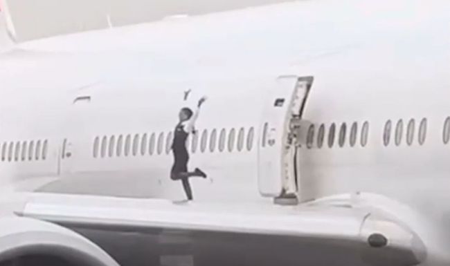 Frau tanzt auf Flugzeug-Flügel 