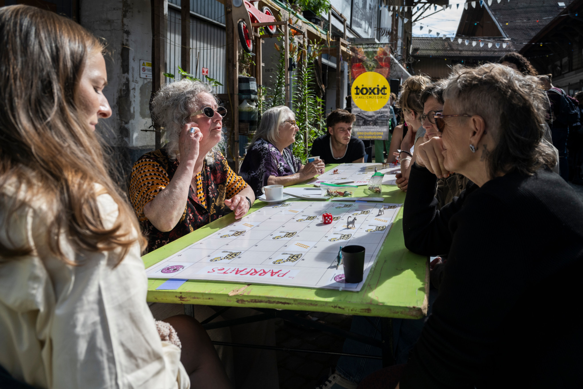 Des femmes sans-abri de Renens, Marseille et Québec échangent autour d’une table verte au Vallon à Lausanne, lors d’une rencontre internationale.