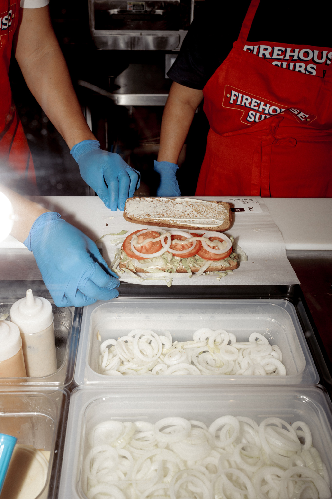 An einer Art Fliessband fügen Angestellte dem Sandwich die Zutaten zu. 