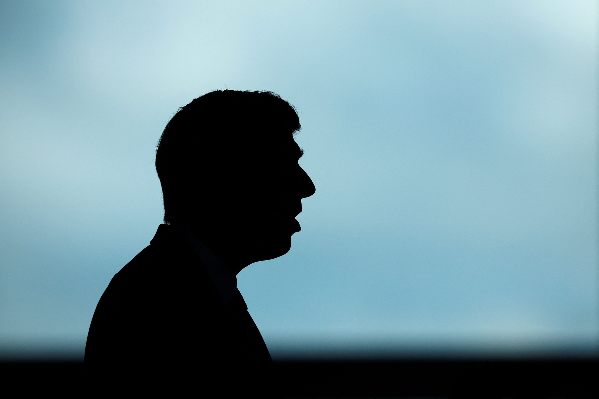 (FILES) Britain's Prime Minister and Conservative Party leader Rishi Sunak is silhouetted as he delivers a speech to launch the Conservatives' general election manifesto in Silverstone, central England, on June 11, 2024, in the build-up to the UK general election on July 4. Rishi Sunak is seeking his own public mandate at next month's general election, on July 4, 2024, having been installed as Conservative leader and UK prime minister by his own colleagues in parliament. The 44-year-old former financier was tasked with stabilising the UK economy, and his own notoriously fractious party, when he succeeded Liz Truss in October 2022 after her 49-day premiership imploded. (Photo by BENJAMIN CREMEL / POOL / AFP)