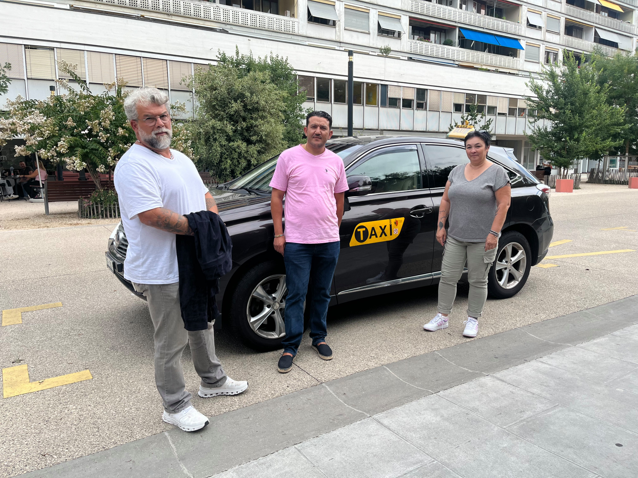 Les membres de la Fédération genevoise des taxis officiels devant l'une de leur voiture.