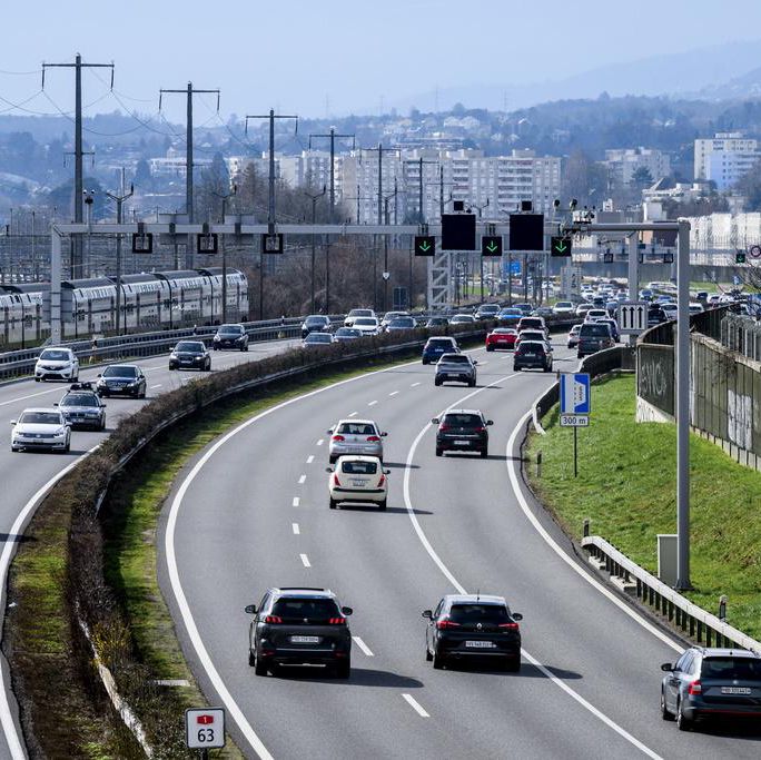 Des véhicules circulent sur l’autoroute A1 près de Denges avec un train des CFF à proximité, la bande d’arrêt d’urgence servant de voie supplémentaire.