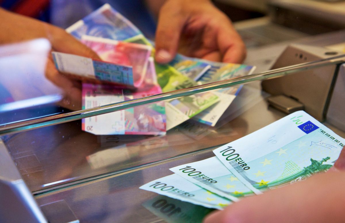 An employee changes Swiss franc, left, and euro notes in this arranged photograph at a currency exchange in Effretikon, near Zurich, Switzerland on Friday, Aug. 12, 2011. The Swiss franc extended its third straight week of gains against the euro after France's economy unexpectedly stalled in the second quarter as demand for exports slackened amid Europe's debt crisis. Photographer: Gianluca Colla/Bloomberg via Getty Images
