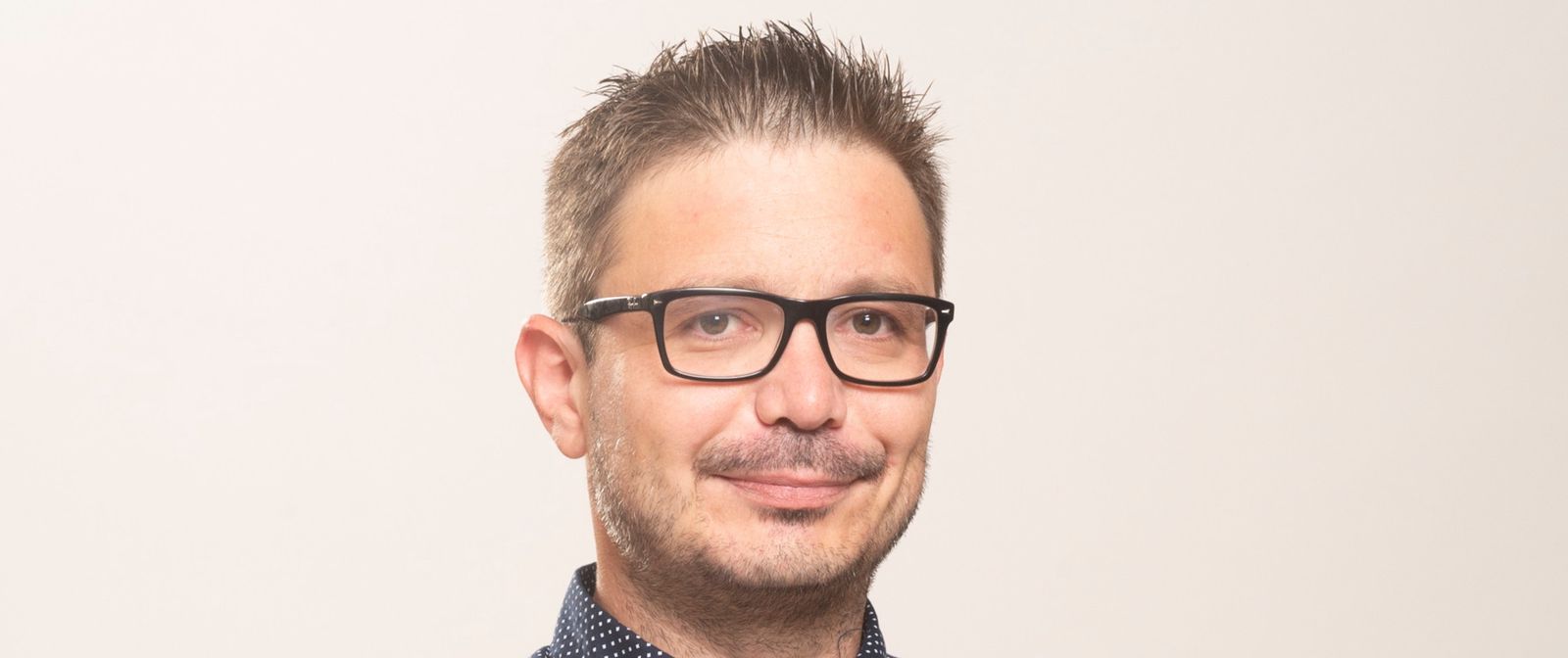 Robin Carrel, journaliste au Sport Center, debout avec une chemise à motifs, souriant et regardant vers l'avant à Lausanne le 30 mai 2018.