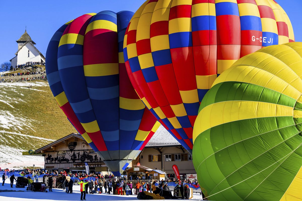 Hot-air balloons take off during the 44th International Hot Air Balloon Festival in Chateau-d'Oex, Switzerland, Saturday, Jan. 20, 2024. (Jean-Christophe Bott/Keystone via AP)
