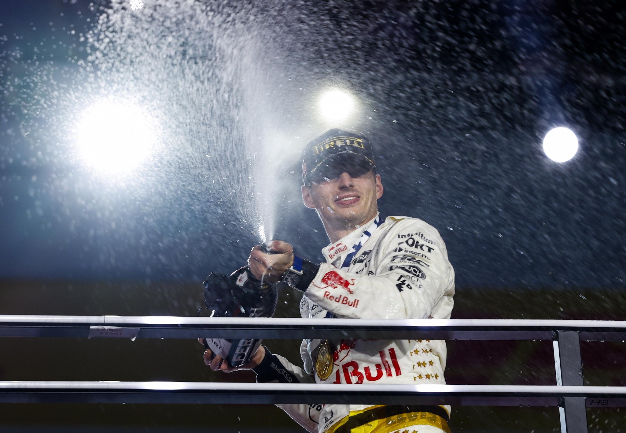 Max Verstappen von Red Bull Racing feiert den Sieg beim Formel-1-Rennen in Las Vegas auf dem Podium mit Champagnerspritzern.