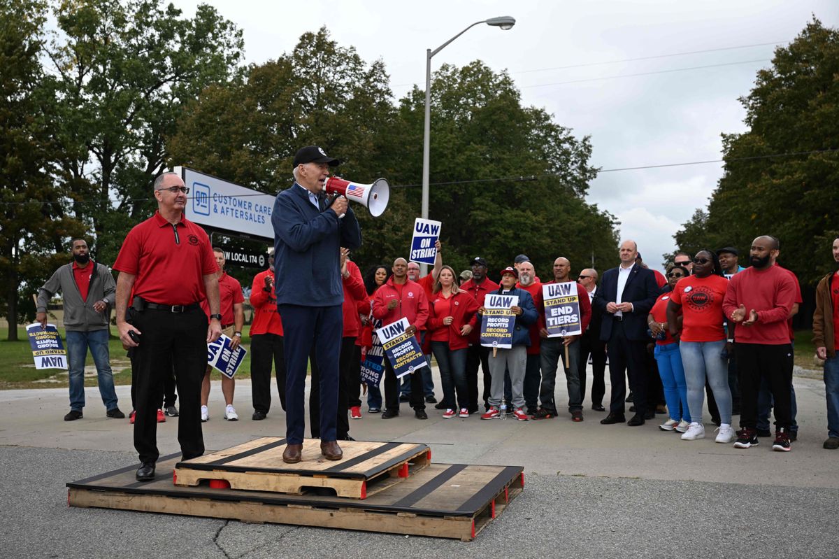 US President Joe Biden addresses striking members of the United Auto Workers (UAW) union at a picket line outside a General Motors Service Parts Operations plant in Belleville, Michigan, on September 26, 2023. Some 5,600 members of the UAW walked out of 38 US parts and distribution centers at General Motors and Stellantis at noon September 22, 2023, adding to last week's dramatic worker walkout. According to the White House, Biden is the first sitting president to join a picket line. (Photo by Jim WATSON / AFP)