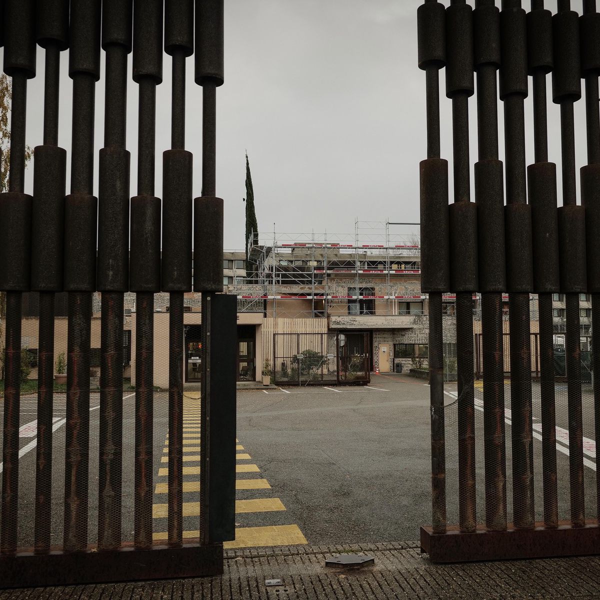 Vue de la prison de Champ-Dollon à Genève, avec portail métallique ouvert sur une cour.