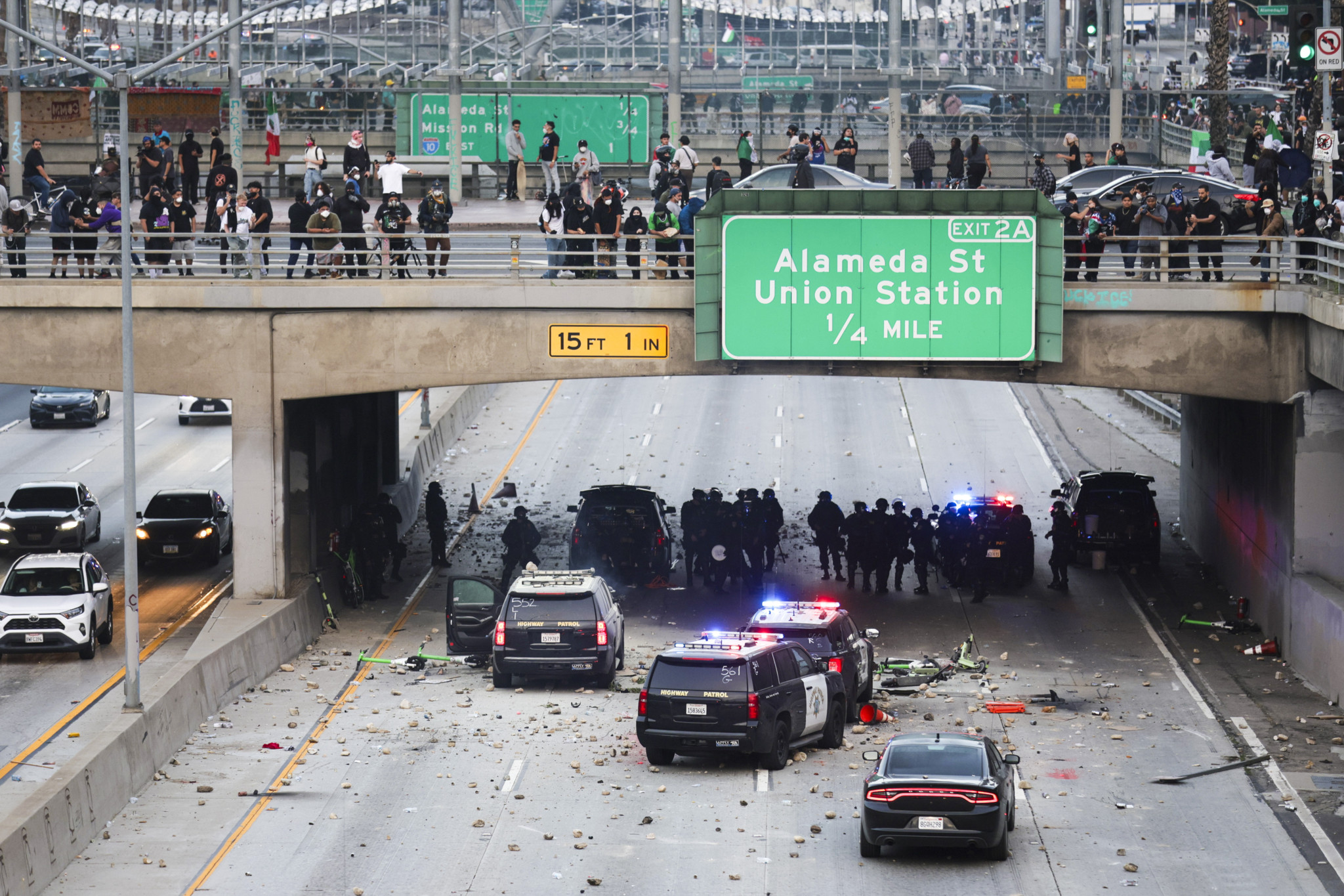 Polizisten suchen Schutz vor Aktivisten, die Steine und Trümmer auf ihre Fahrzeuge werfen, während Protesten gegen Einwanderungsrazzien in Los Angeles am 8. Juni 2025.