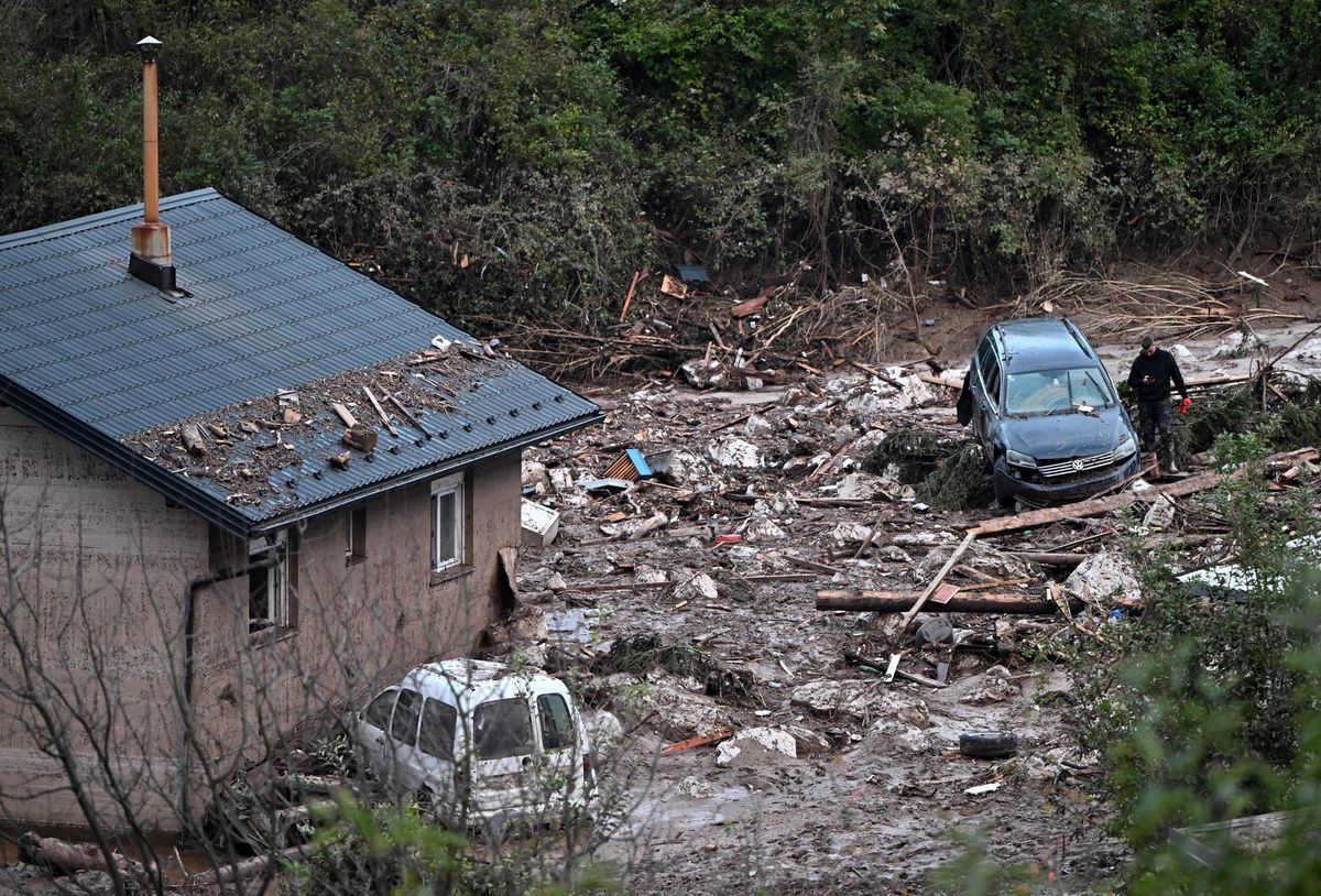 Photo taken in village of Donja Jablanica, about 50 kilometres south-west of Sarajevo on October 6, 2024, shows a man walking after mud, boulders and debris were cleared following a landslide that hit the village due to heavy rains on October 4. The search for dozens of people reported missing in floods that have claimed at least 17 lives in Bosnia continued on October 6, after torrential rains inundated towns and triggered landslides. (Photo by ELVIS BARUKCIC / AFP)