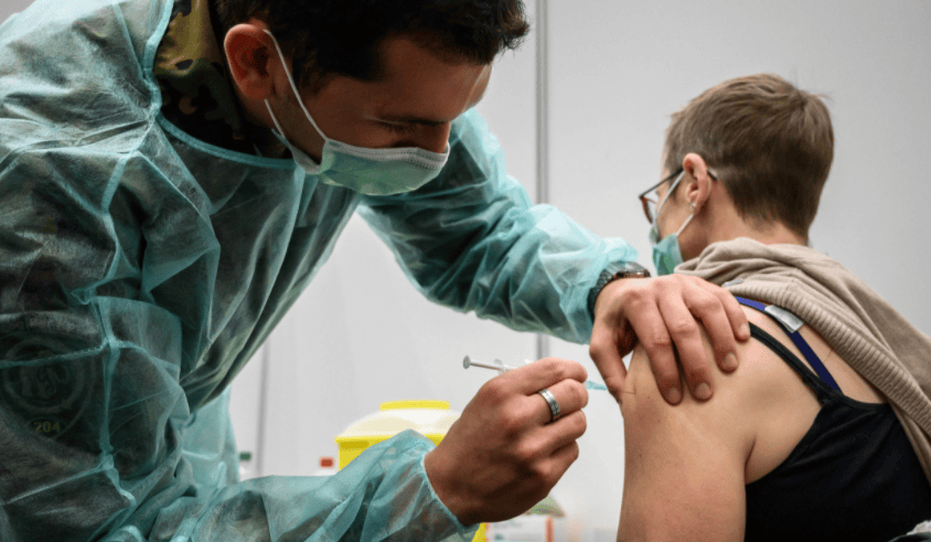 Cette femme se fait administrer la 3e dose par un soldat à Delémont. 