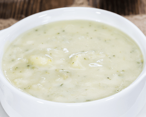 Bol de soupe crémeuse aux pommes de terre, garnie de persil haché.