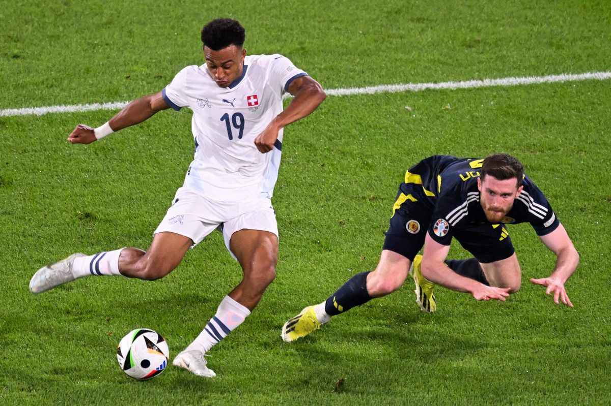 Switzerland's forward #19 Dan Ndoye kicks the ball next to Scotland's defender #02 Anthony Ralston during the UEFA Euro 2024 Group A football match between Scotland and Switzerland at the Cologne Stadium in Cologne on June 19, 2024. (Photo by Kirill KUDRYAVTSEV / AFP)