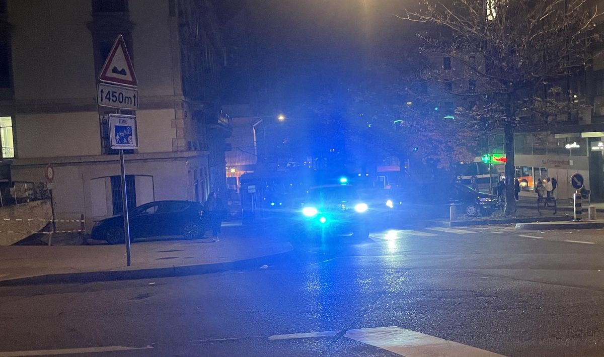Voiture de police avec gyrophares allumés dans une rue sombre.