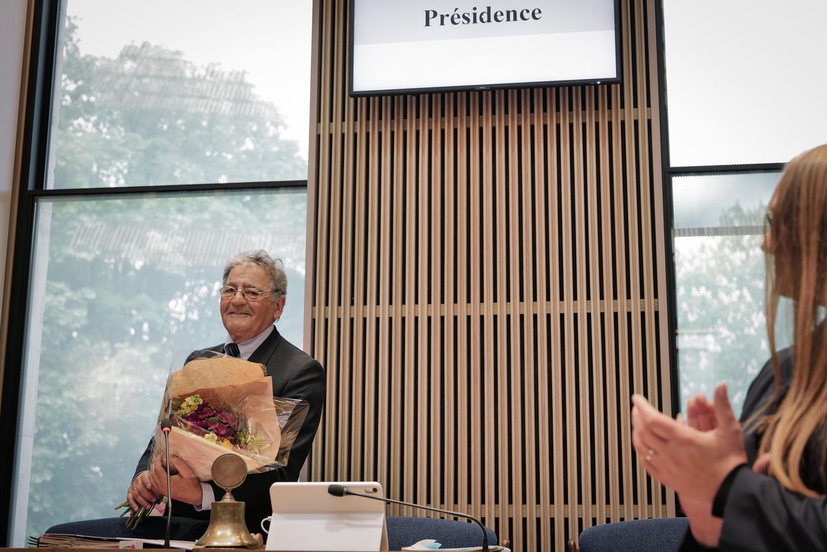 Le député Alberto Velasco, tenant un bouquet de fleurs, est applaudi dans la salle du Grand Conseil à Genève lors de son élection à la présidence, avec la conseillère d'Etat Carole-Anne Kast au premier plan.