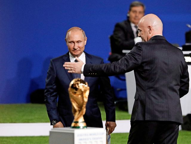 Gianni Infantino, président de la FIFA, et Vladimir Poutine, qui a le regard fixé sur un trophée fort convoité.