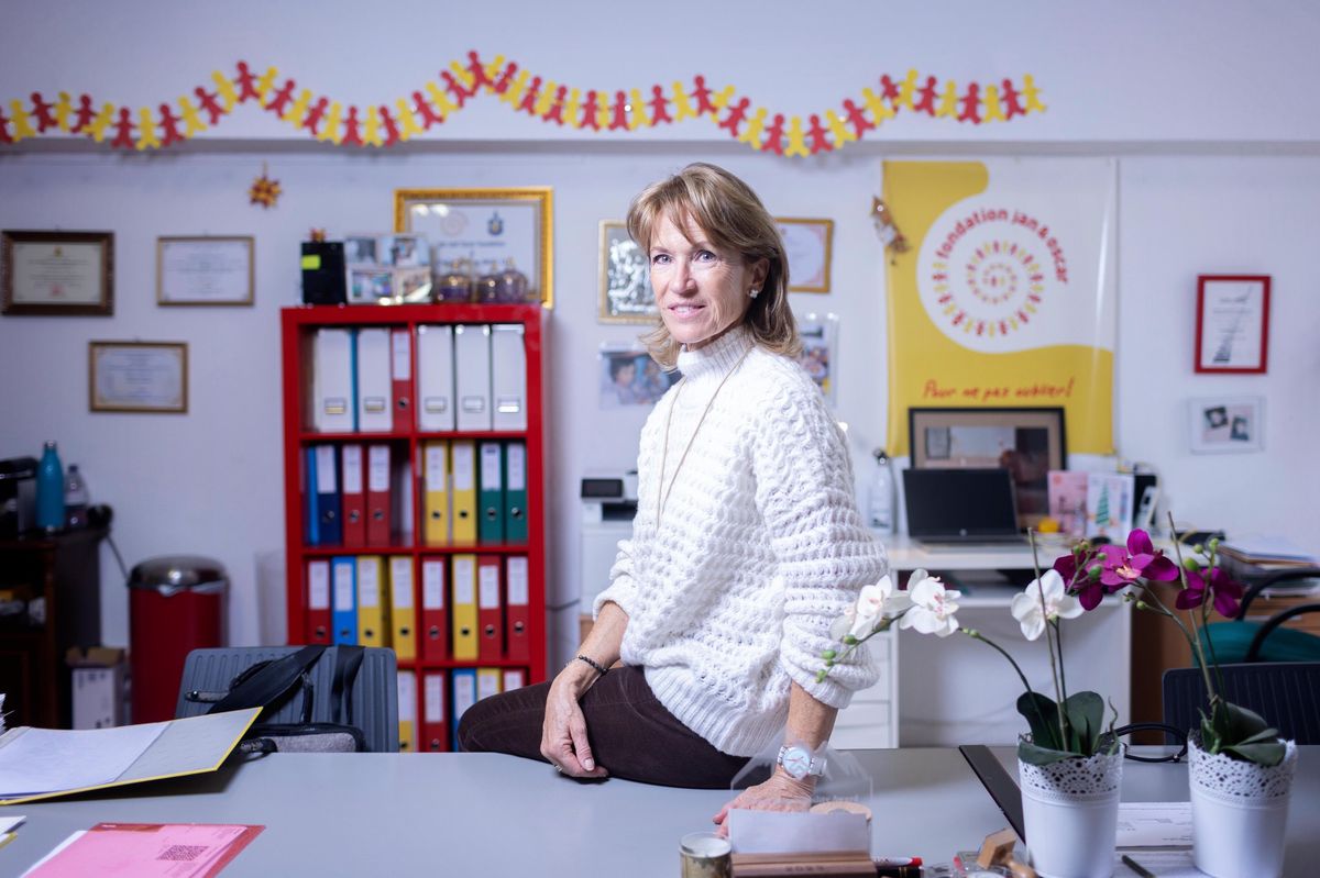 Laurence Pian, présidente de la Fondation Jan et Oscar, assise dans un bureau décoré de dossiers colorés et de plantes.