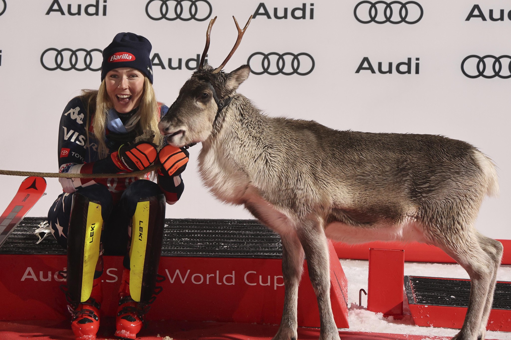 Mikaela Shiffrin mit einem Rentier auf dem Podium nach dem Gewinn eines Slalom-Weltcup-Rennens in Levi, Finnland.