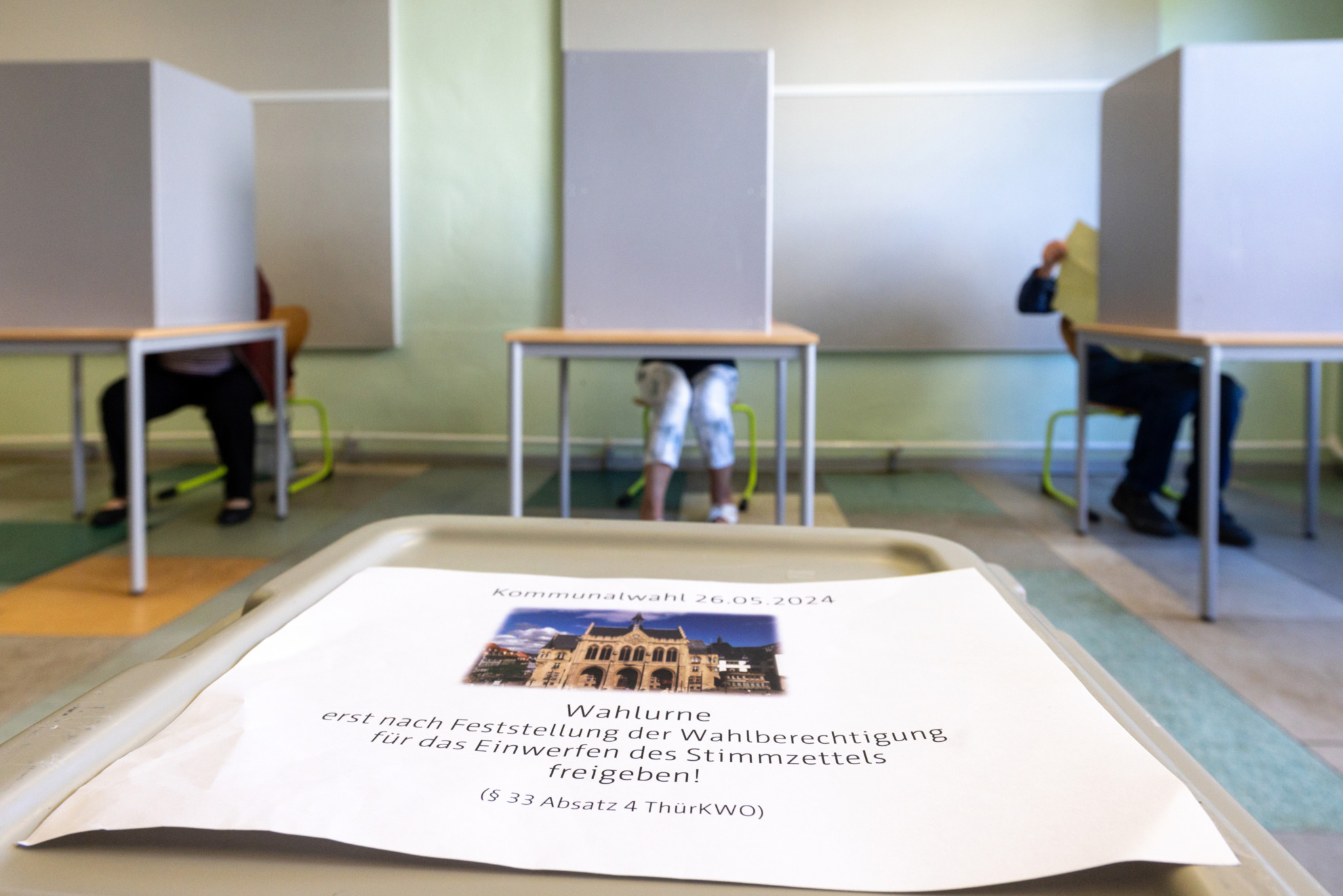 26.05.2024, Thüringen, Erfurt: Wähler geben bei den Kommunalwahlen in Thüringen in einem Wahllokal ihre Stimmen ab. Gewählt werden 17 Kreistage, Stadträte und Oberbürgermeister in den 5 kreisfreien Städten und Landräte in 13 Landkreisen, dazu kommen die Wahlen für 600 Stadt- und Gemeinderäte. Foto: Michael Reichel/dpa +++ dpa-Bildfunk +++