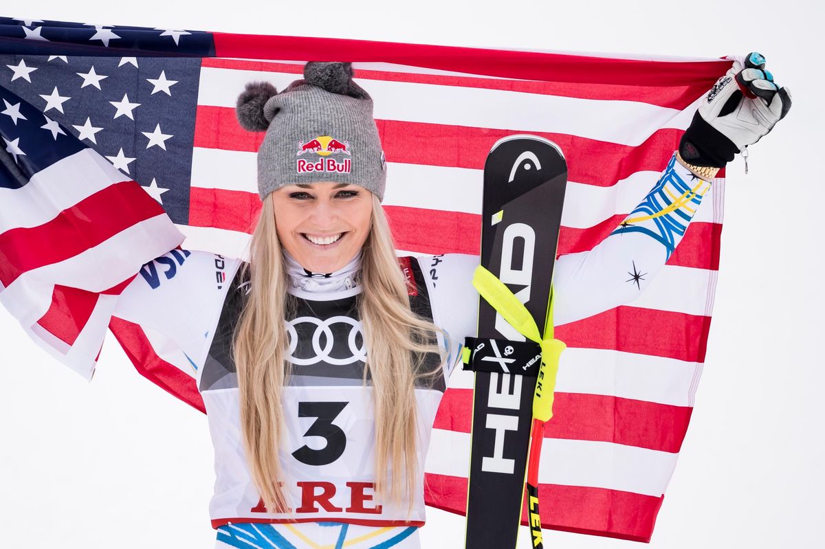 Lindsey Vonn, médaillée de bronze, célèbre avec un drapeau américain lors de la cérémonie de fleurs du championnat du monde de ski alpin 2019 à Are, Suède.