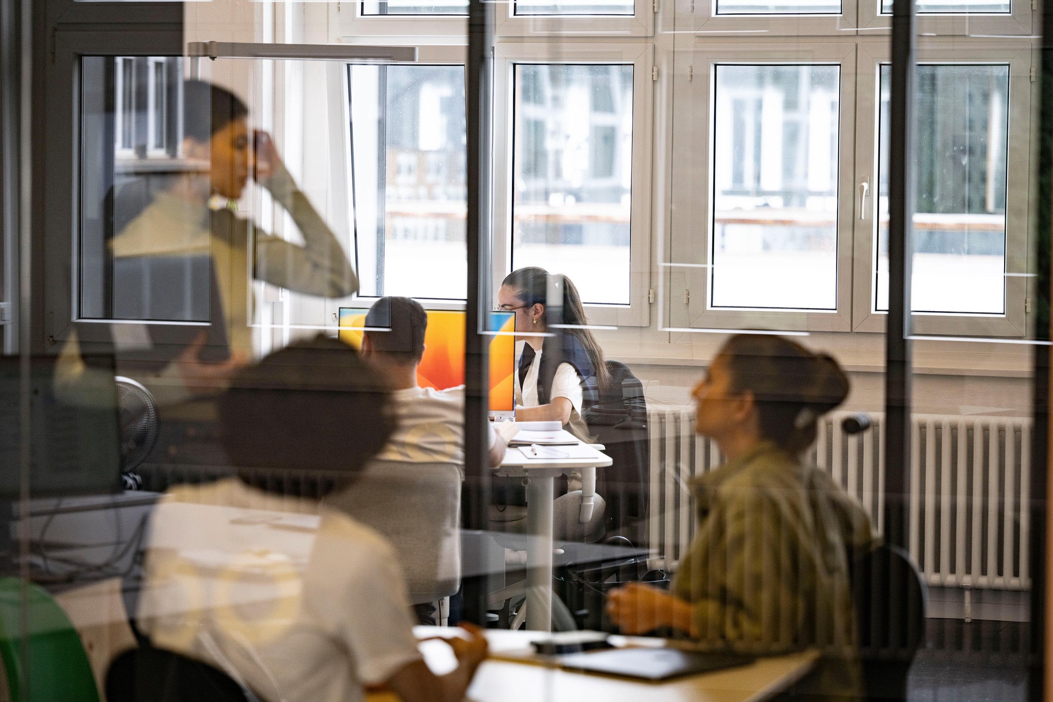 Des employés de Boostbar travaillent dans un bureau à Zurich, avec des fenêtres en arrière-plan, photographiés le 21 septembre 2023.