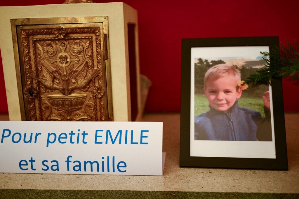 This photograph taken on March 21, 2024, inside a chapel in La Bouilladisse southern France, shows a card with the inscription reading "For the little Emile and his family" next to a portrait of Emile, a missing boy, who disappeared on July 8, 2023 in Le Vernet, southeastern France. (Photo by CHRISTOPHE SIMON / AFP)