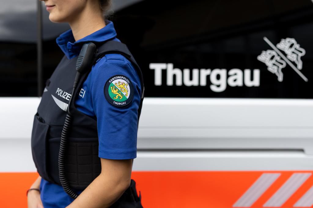 Policière en uniforme de la Kantonspolizei Thurgau, avec équipement, devant un véhicule de police à Frauenfeld.
