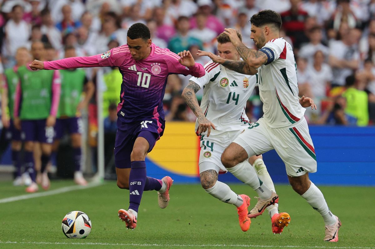 Germany's midfielder #10 Jamal Musiala is marked by Hungary's defender #14 Bendeguz Bolla and Hungary's midfielder #10 Dominik Szoboszlai during the UEFA Euro 2024 Group A football match between Germany and Hungary at the Stuttgart Arena in Stuttgart on June 19, 2024. (Photo by LLUIS GENE / AFP)