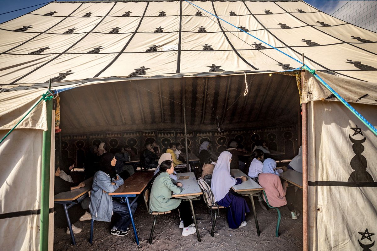 Students attend class in a tent at a make-shift school in the earthquake-hit village of Asni in al-Haouz province in the High Atlas mountains of central Morocco on September 18, 2023. Nearly 3,000 people were killed and thousands more injured when a 6.8-magnitude earthquake tit Morocco's Al-Haouz province on September 8. In its aftermath, many worry that the dire living conditions and poor hygiene spell new threats for the survivors. (Photo by FADEL SENNA / AFP)