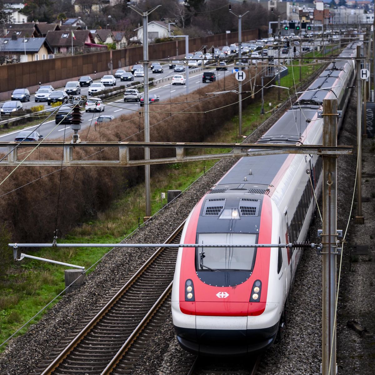Des véhicules circulent sur l’autoroute A1 proche de Morges, à côté d’un train CFF, avec la bande d’arrêt d’urgence utilisée comme troisième voie pour fluidifier le trafic.