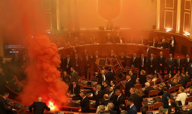 An MP of the Democratic Party, Albania's biggest opposition party, lights a coloured smoke bomb as a sign of protest during a parliament session in Tirana, Albania, November 20, 2023 REUTERS/Florion Goga