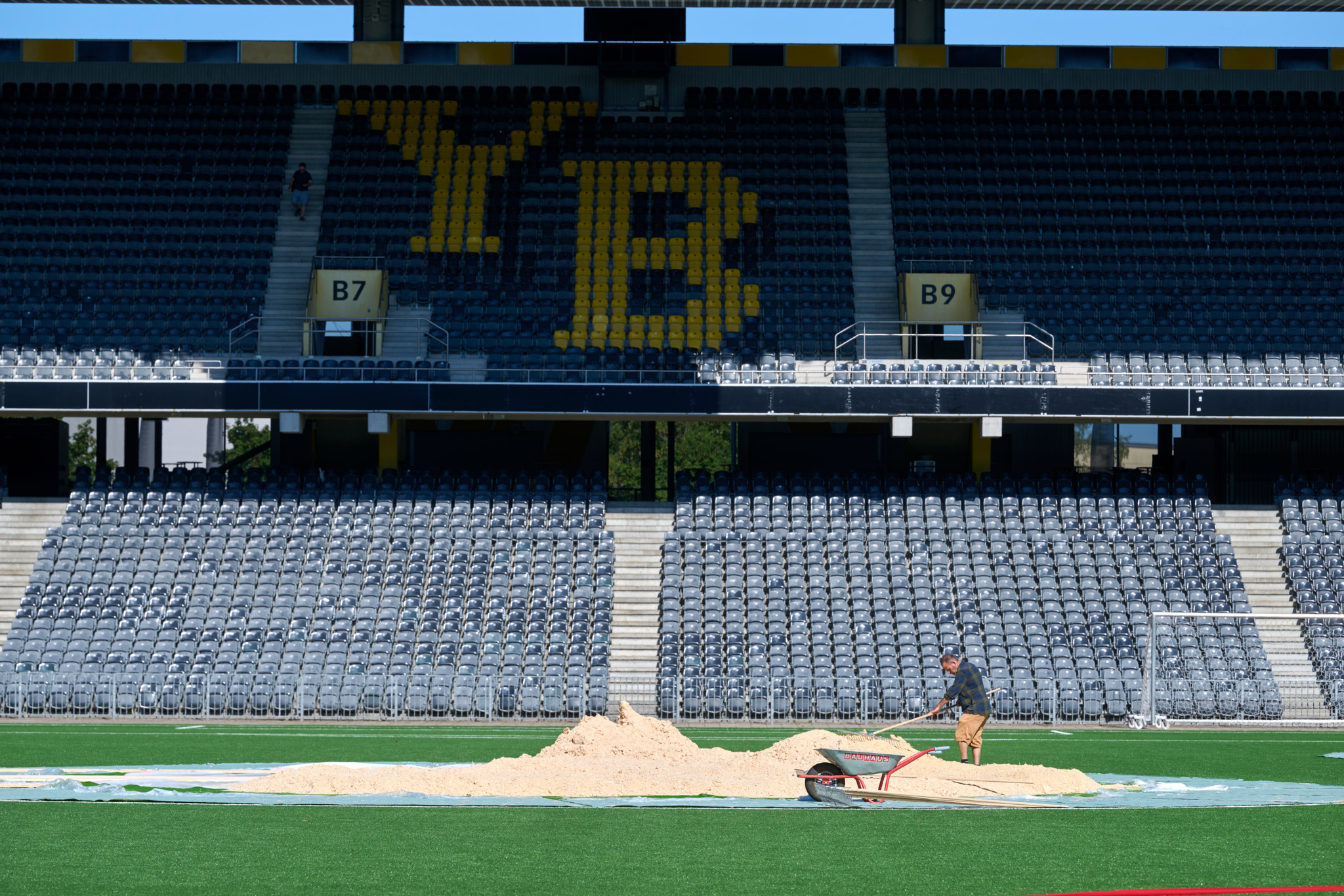 Vorbereitungen für das kantonale Schwingfest im Wankdorf-Stadion: Ein Arbeiter schüttet Sägemehl auf den Kunstrasen, im Hintergrund das YB-Logo auf den Tribünen. Vorbereitungen für das kantonale Schwingfest im Wankdorf-Stadion: Ein Arbeiter schüttet Sägemehl auf den Kunstrasen, im Hintergrund das YB-Logo auf den Tribünen.