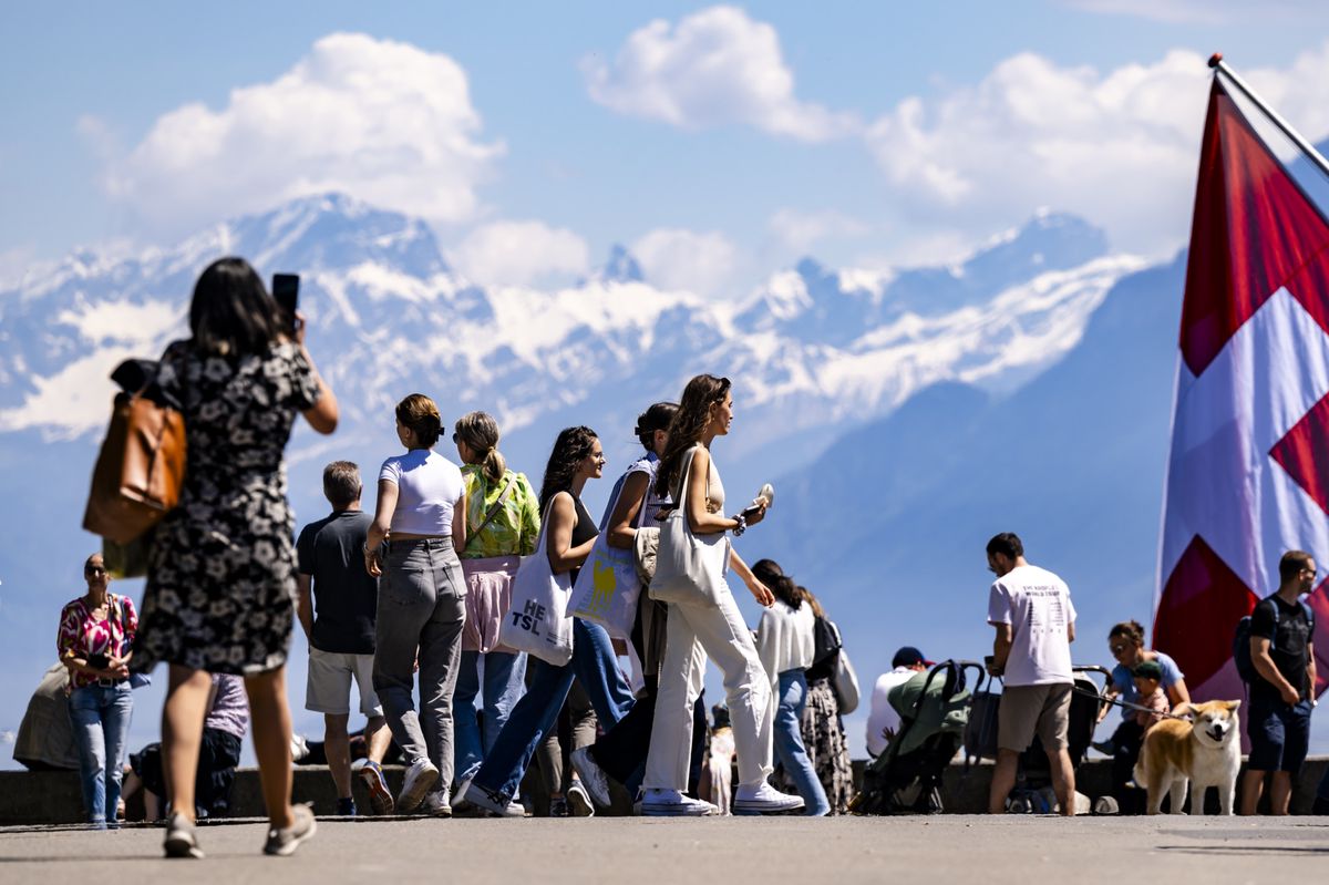 Des personnes profitent du soleil et du beau temps en marchant sur les quais d'Ouchy au bord du Leman lors du week-end de l'Ascension le samedi 11 mai 2024 a Lausanne. (KEYSTONE/Jean-Christophe Bott)