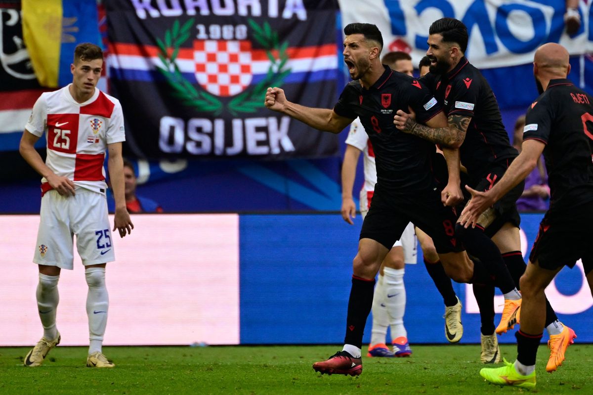 Albania's midfielder #08 Klaus Gjasula celebrates with his team mates after scoring the equalising goal 2:2 during the UEFA Euro 2024 Group B football match between Croatia and Albania at the Volksparkstadion in Hamburg on June 19, 2024. (Photo by JOHN MACDOUGALL / AFP)