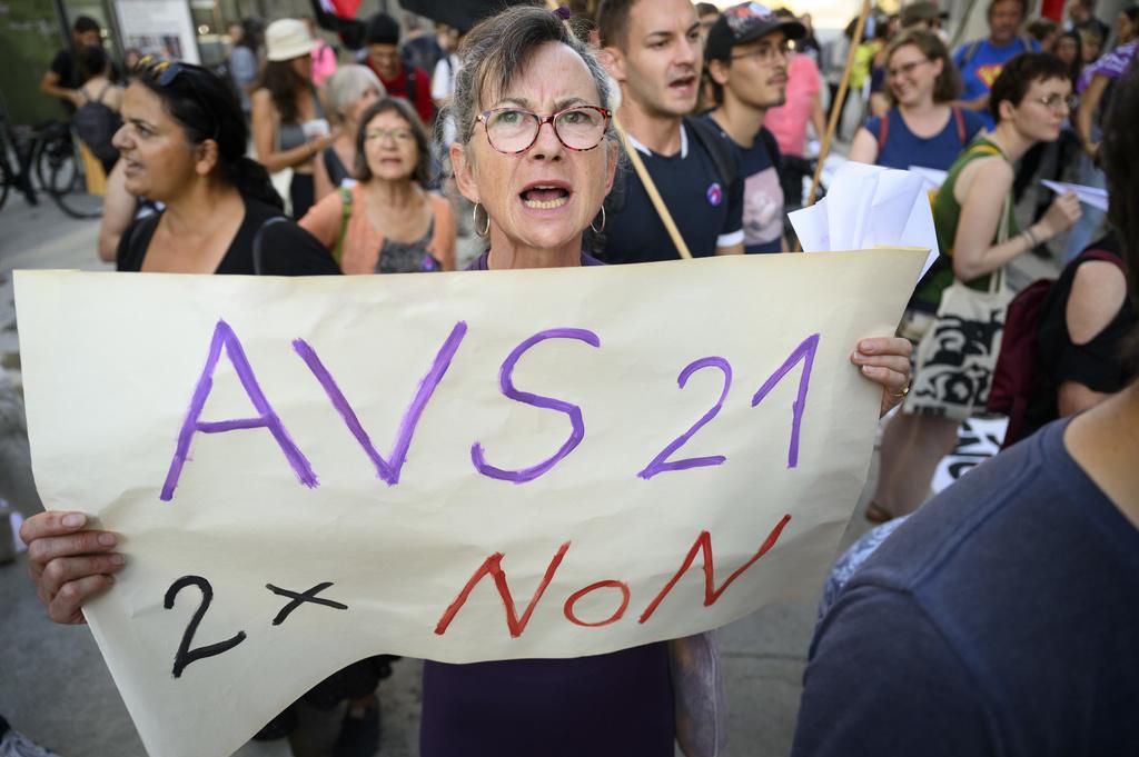 Manifestants brandissent une pancarte contre AVS 21 et l’augmentation de la TVA à Lausanne, près du Musée Cantonal des Beaux-Arts.