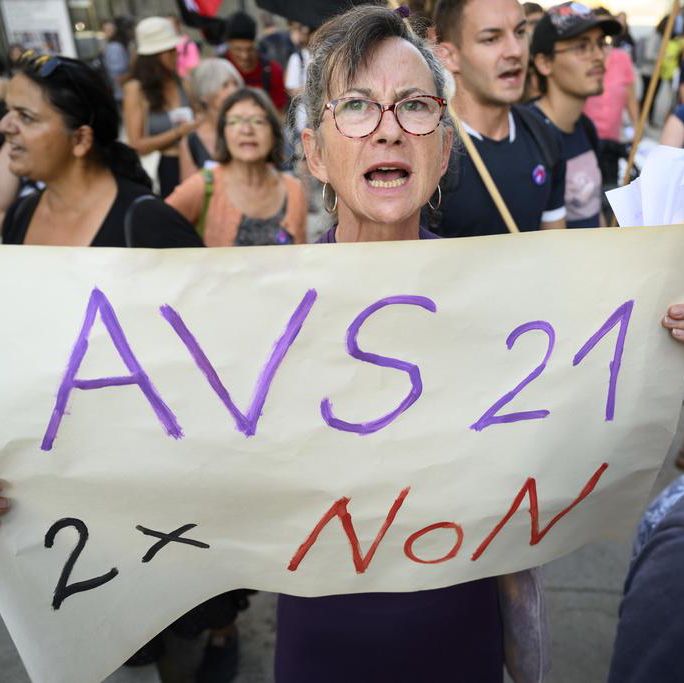 Manifestants brandissent une pancarte contre AVS 21 et l’augmentation de la TVA à Lausanne, près du Musée Cantonal des Beaux-Arts.