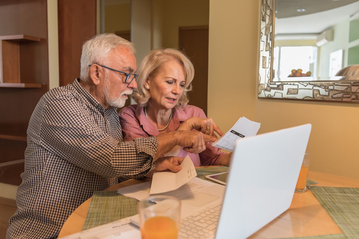 Older Man and his Beautiful Wife are Feeling Displeased when Calculating Home Finances.