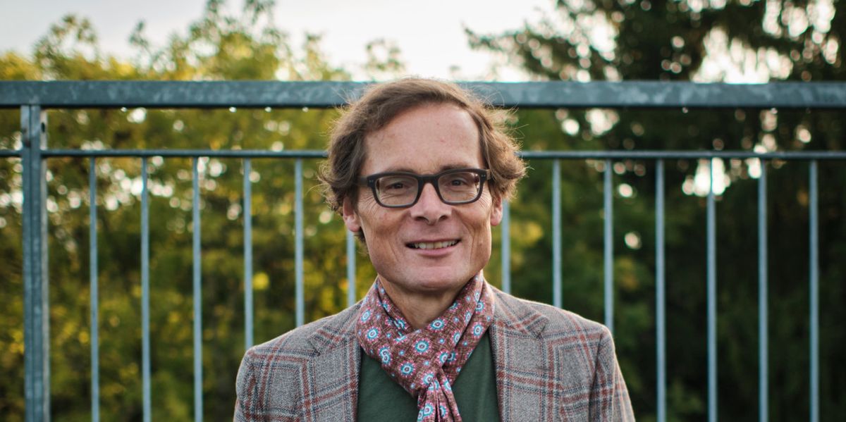 Roger Köppel auf dem Balkon der Weltwoche-Redaktion in Zollikon mit einer Tasse und einem karierten Schal.